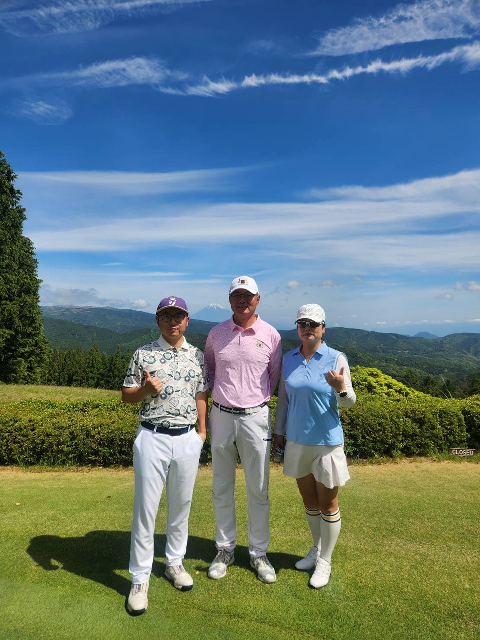 Participants posing for a photo on a golf course in the Izu region